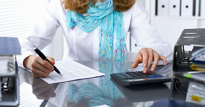 Studentin der Wirtschaft sitzt an Schreibtisch und überprüft eine Rechnung