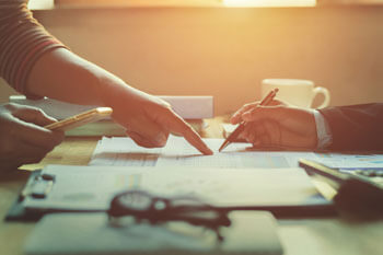 Ein Wirtschaftsprüfer bespricht Dokumente mit einem Mandanten